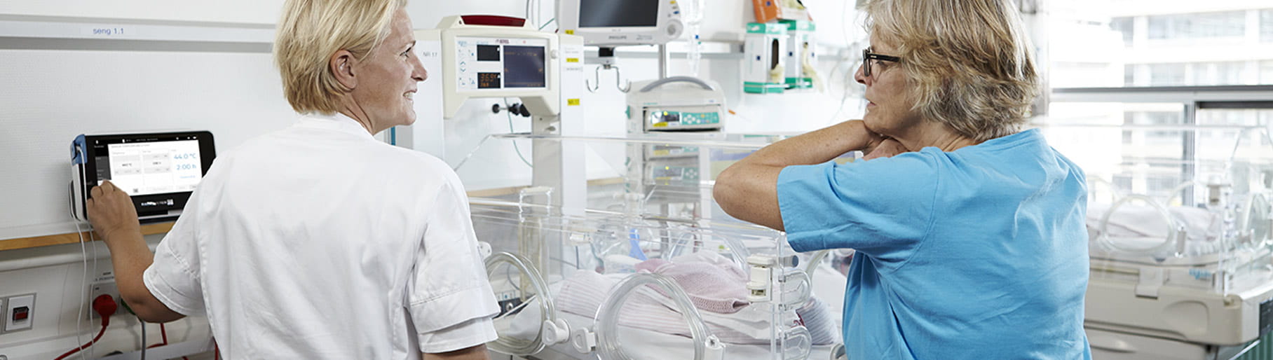 Situación en un hospital: dos enfermeras de la UCIN utilizando un monitor transcutáneo de Radiometer